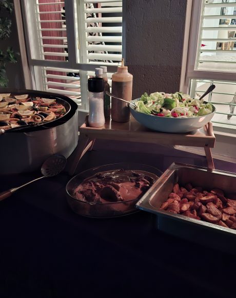 Live paella catering buffet with fresh seafood paella, roasted potatoes, salad, and roast beef served at a private event in Randburg.
