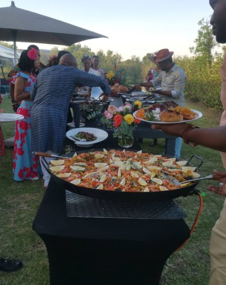 Guests enjoying paella and buffet catering at an outdoor celebration