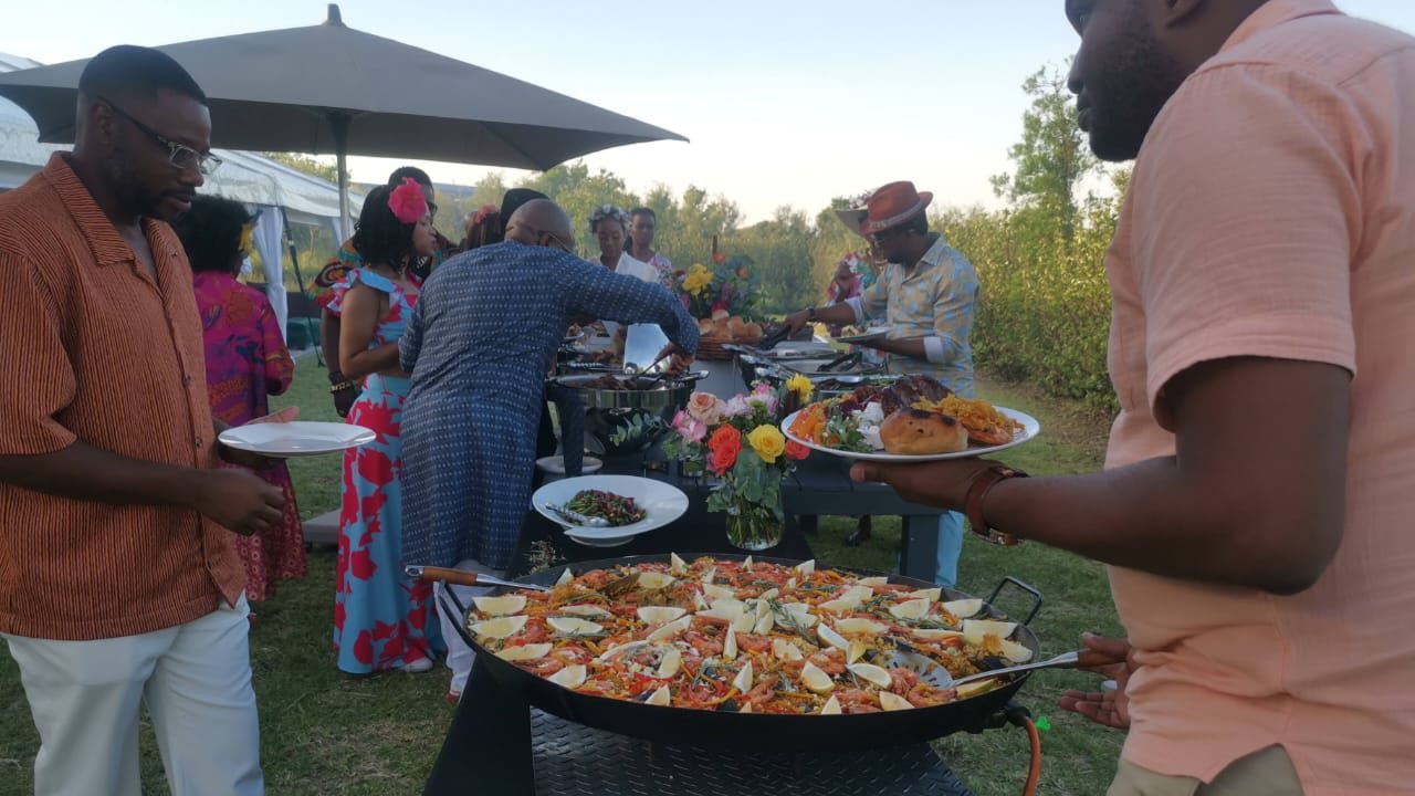 Guests enjoying paella and buffet catering at an outdoor celebration