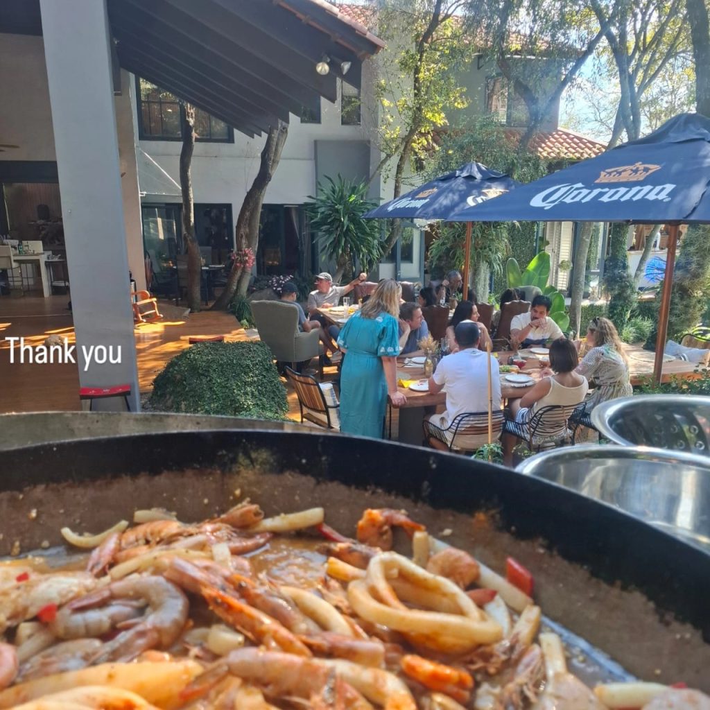 Seafood paella being served at an outdoor private garden event