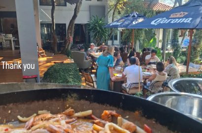 Seafood paella being served at an outdoor private garden event