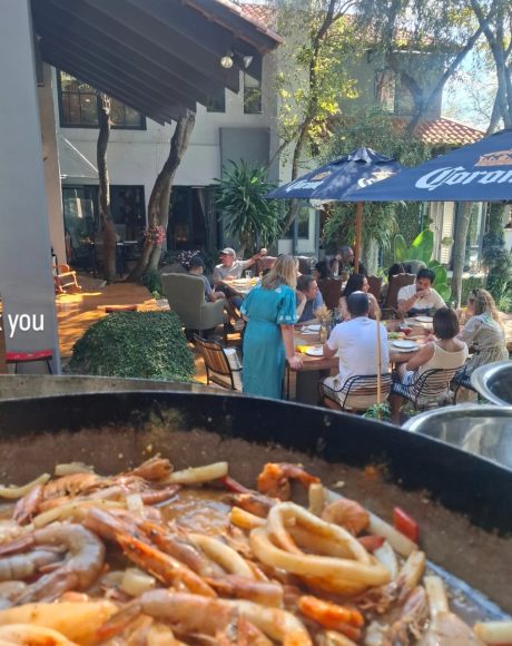 Seafood paella being served at an outdoor private garden event