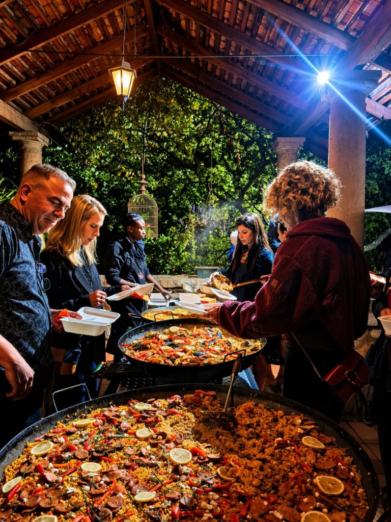 Guests being served paella at an evening catered function
